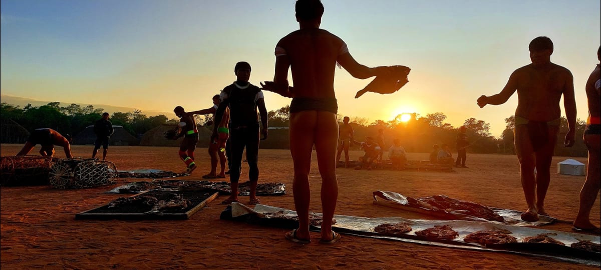 Tiogo Kalapalo (no centro) distribuindo peixes para os moradores da Aldeia Aiha Kalapalo, na Terra Indígena do Xingu, como parte do processo de agradecimento do dono do ritual Kuarup à pela contribuição da comunidade, que juntou polvilho para alimentar os participantes do evento|Tauana Kalapalo/2022