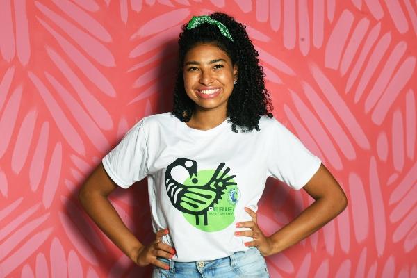 Amanda costa posa para foto em frente a uma parede vermelha e rosa