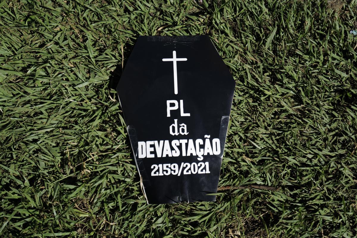 Cartaz em formato de caixão escrito "PL da devastação 2159/2021" no Acampamento Terra Livre 2024