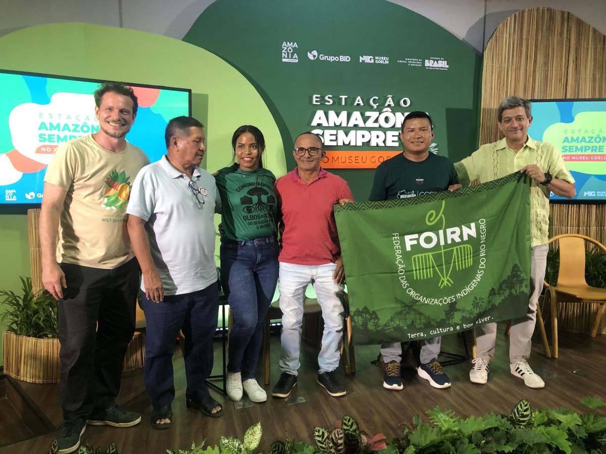 Palestrantes seguram bandeira da FOIRN em foto final, no Museu Goeldi, em Belém