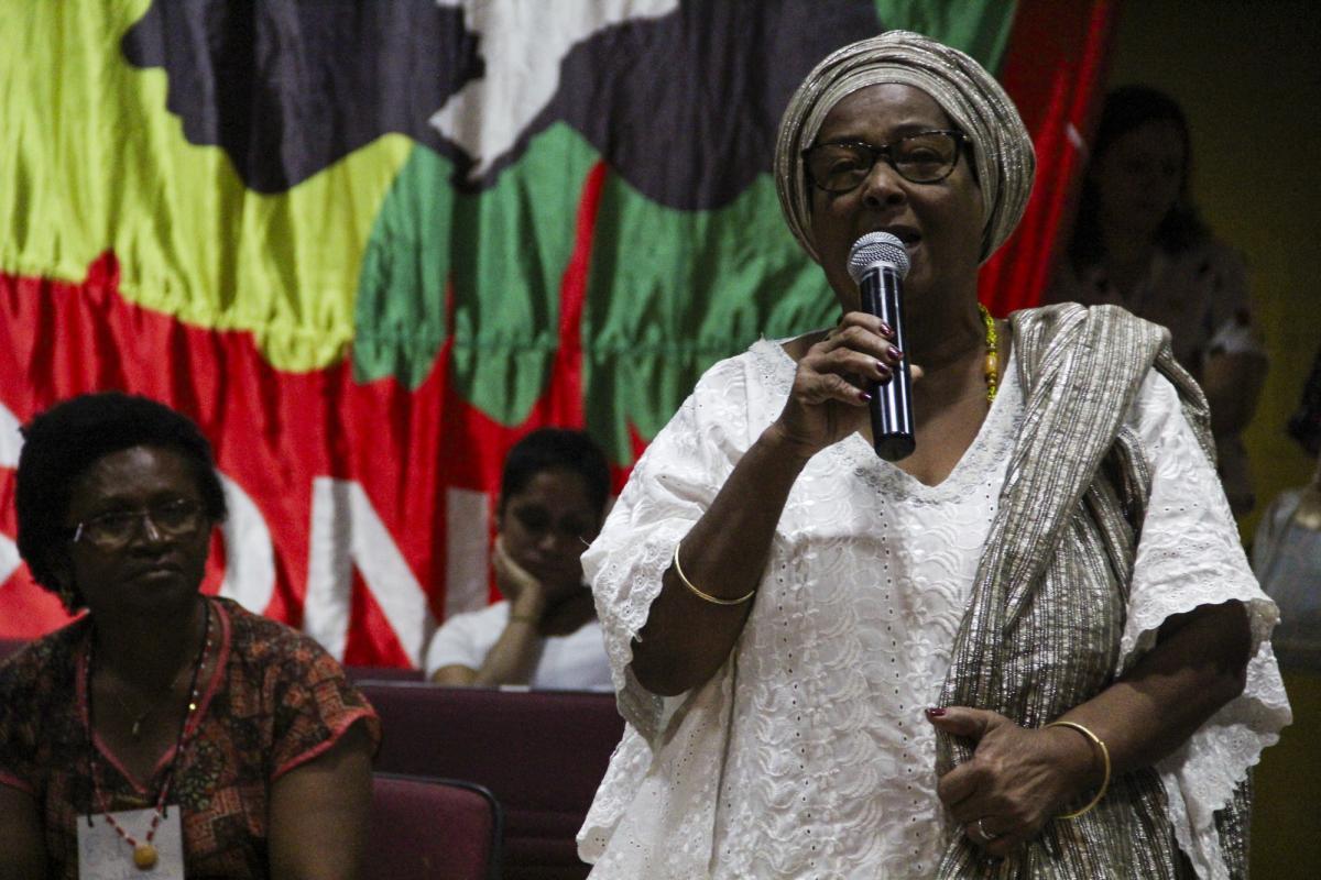 Imagem mostra Mãe Bernadete falando ao microfone